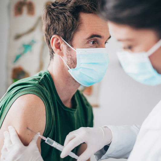 Have vaccination certificate translated: A young man wearing a respirator receives his vaccination