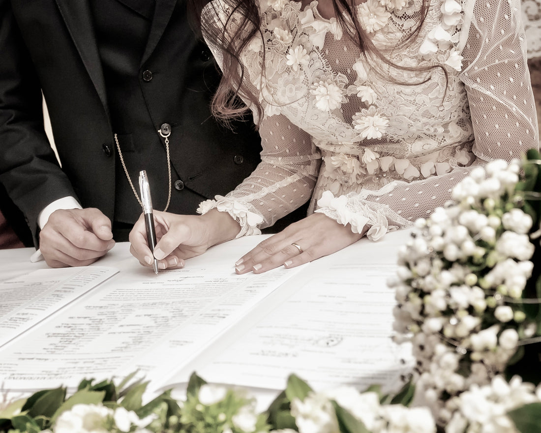 Ein neues Ehepaar unterschreibt die Heiratsurkunde - Ratgeber alles rund um die Heiratsurkunde